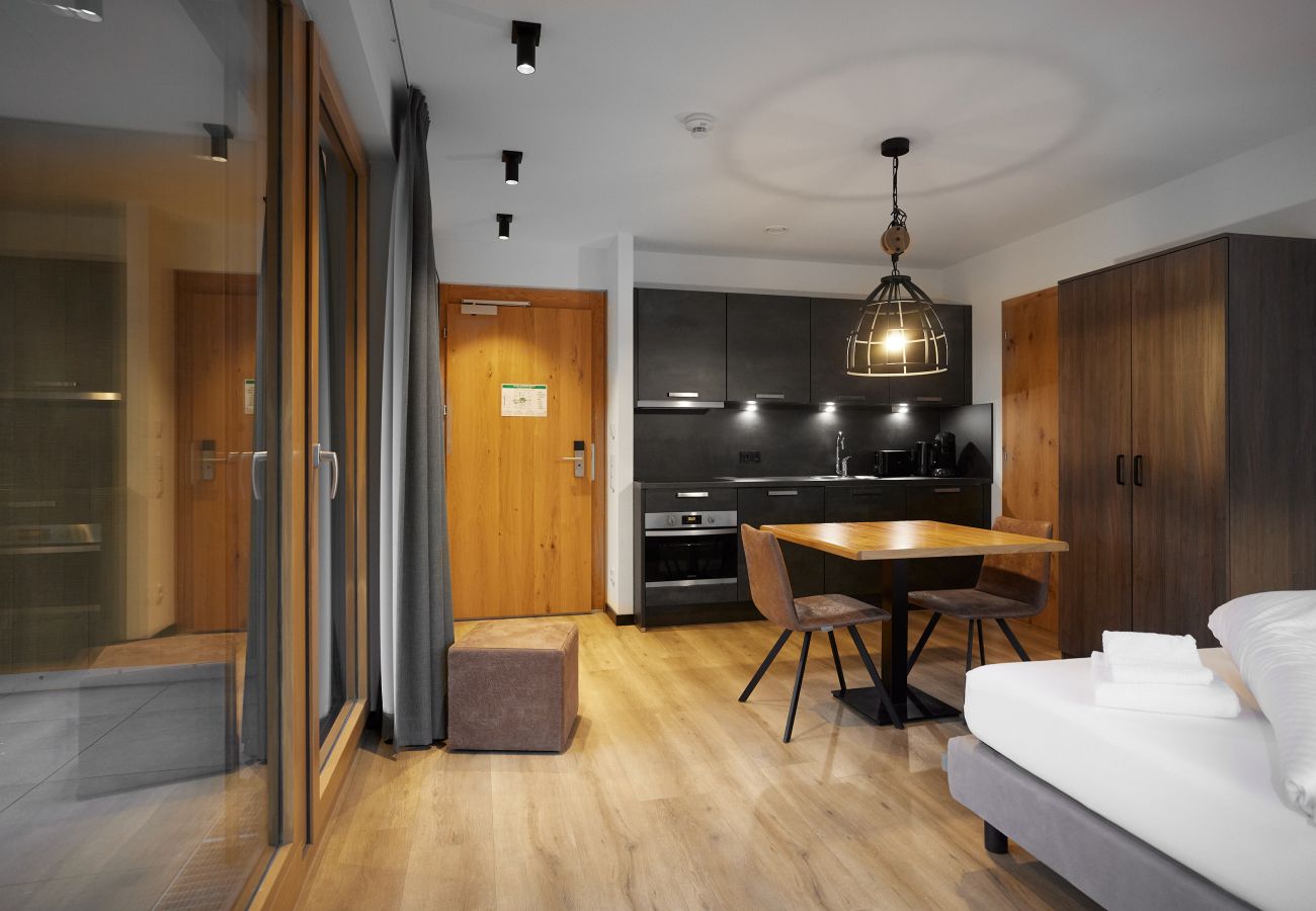 Woonkamer met bed, tafel en keuken in het Specht 109 Alpin-Resort Montafon