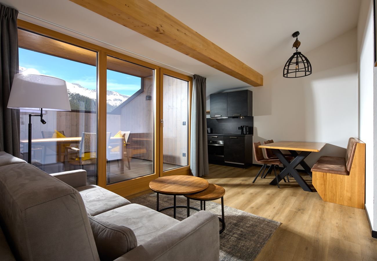 Woonkamer met bank, tafel en keuken in het Mauerläufer 322 Alpin-Resort Montafon