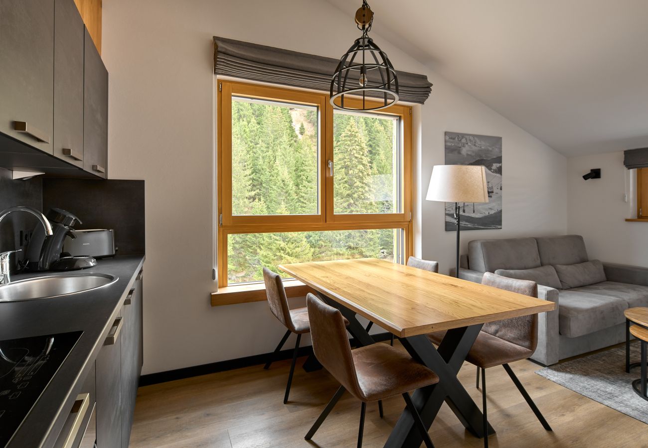 Living area with sofa, table and kitchen in the Bartgeier 219 Alpin-Resort Montafon