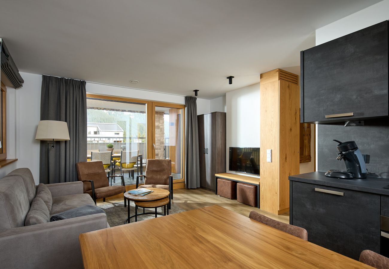 Wohnbereich mit Sofa, Tisch und Küche im Alpen-Dohle 201 Alpin-Resort Montafon
