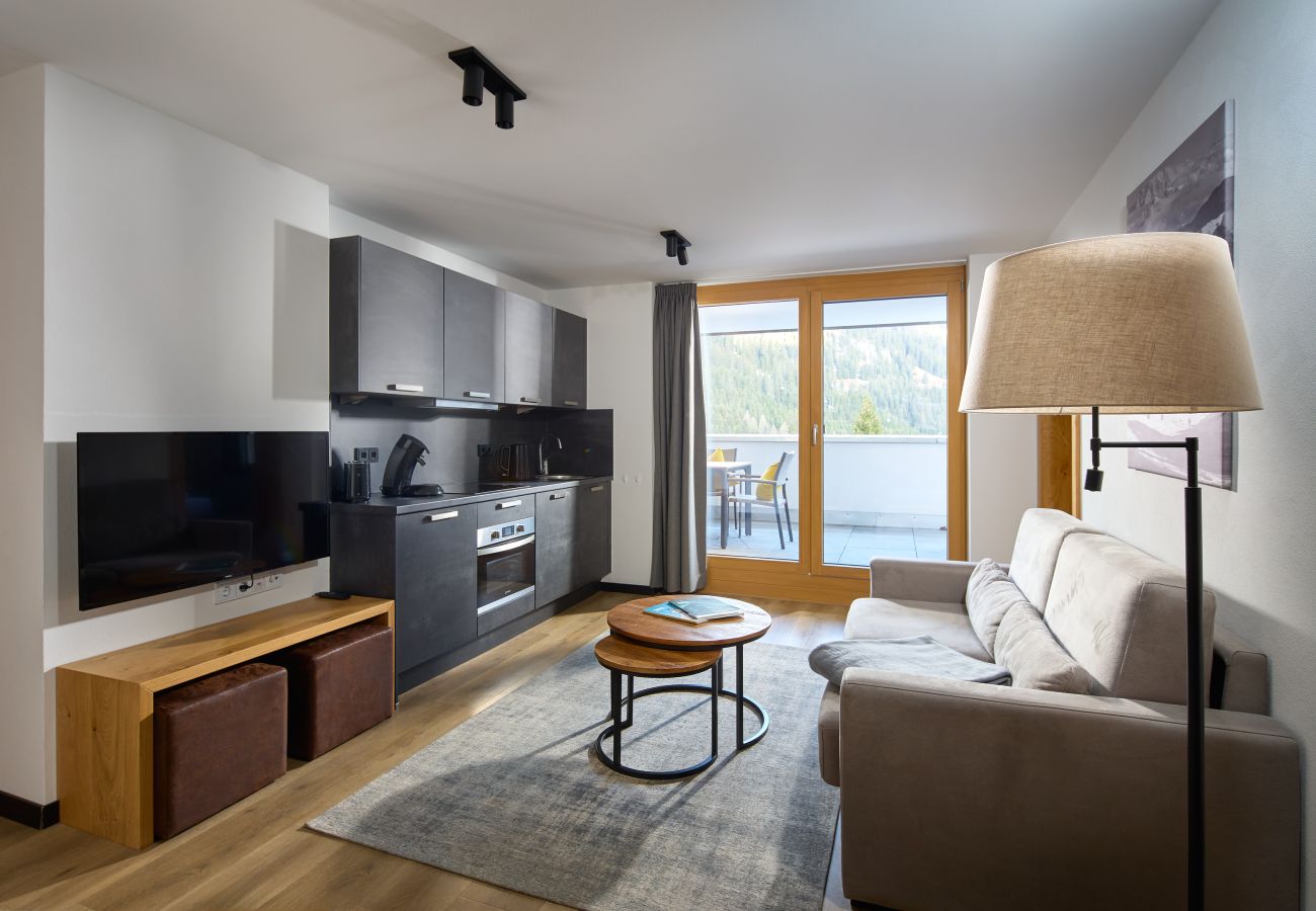 Wohnbereich mit Sofa und Küche im Steinadler 310 Alpin-Resort Montafon