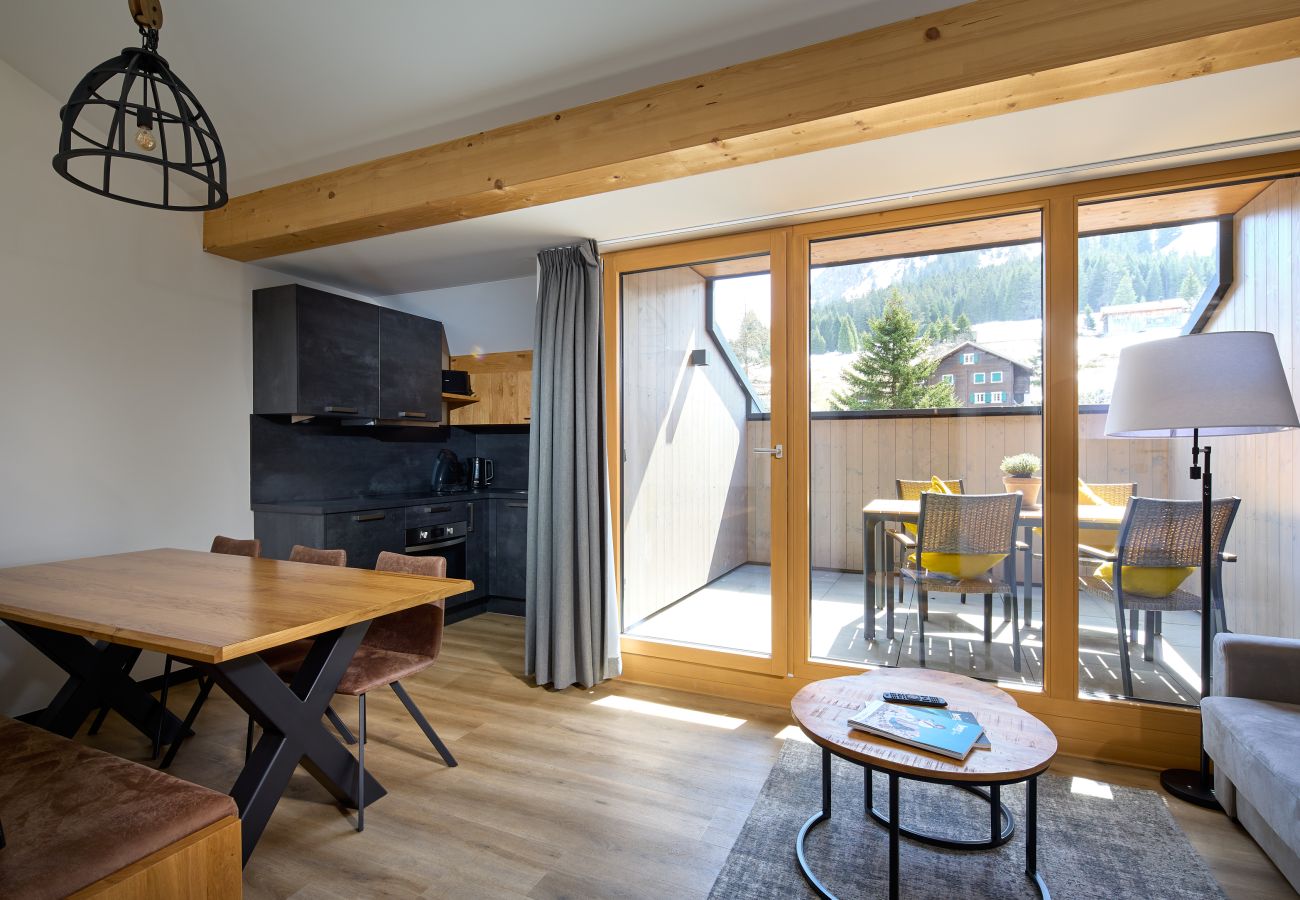 Wohnbereich mit Sofa, Tisch und Küche im Mauerläufer 324 Alpin-Resort Montafon